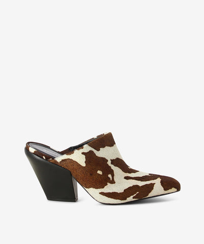 Brown and white cow print pony hair leather mules by Sempre Di. It is a slip-on style and features a Cuban heel and a chisel toe.