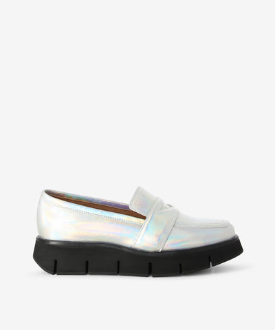 Holographic silver leather platform loafers by Alfie & Evie. It is a slip on style and features a chunky platform sole, and a soft square toe.