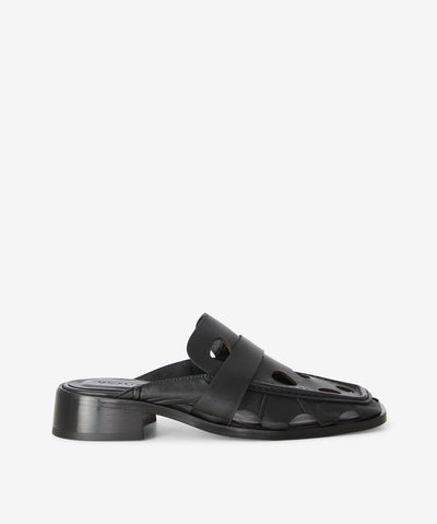 Black premium leather slide by Beau Coops. It is a slip-on style with an oversized punched upper and moccasining stitch an enclosed upper that features a stylish edge to the traditional look, a low block heel, and a square toe. 