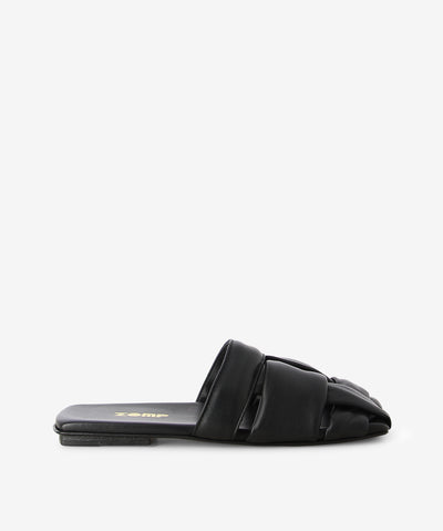 Black leather slides by Zomp. It is a slip-on style and features a large open-weave upper, low heel and a semi-enclosed square toe.