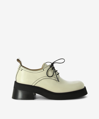 Beige leather with contrast black stitching and tied to the front with tidy black laces loafers by Miista. A lace-up style and features curved upper panel, rear tabs, a medium block heel and a round toe.
