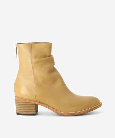 Camel leather ankle boots by Django & Juliette. It features a ruched slouch upper, rear zip closure, and a round toe.