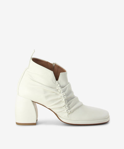 White leather ankle boots with an inner zip fastening and features ruched leather detailing, a block heel and an anatomic square toe.