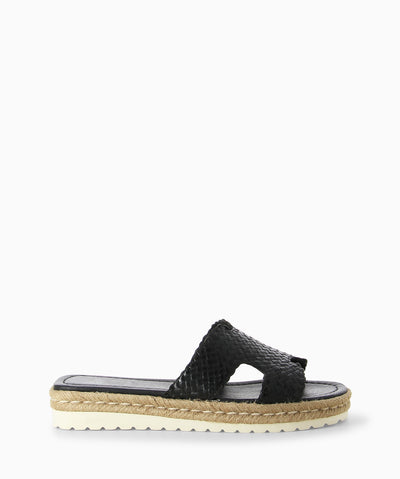 Black leather slides with a woven leather upper, an espadrille outsole and a round toe.  