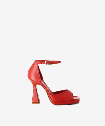 Red leather heels by Zomp. It has a back strap and features an hourglass heel and a square toe.