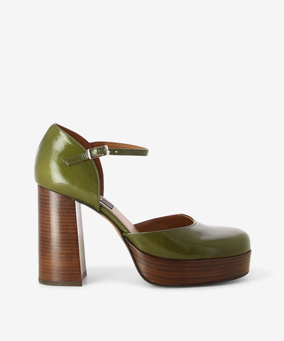 Green patent leather platform leather by Neo. It features a block heel and front platform, adjustable pin-buckle strap, and an enclosed round toe.