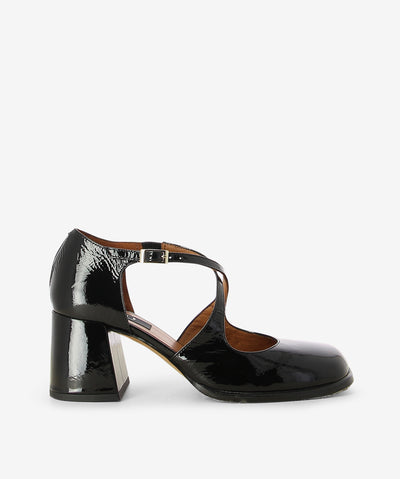 Black crinkle patent leather heels by Neo. It features a block heel, front cross straps with an adjustable pin-buckle strap, and a soft square toe.