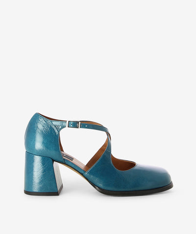 Blue crinkle patent leather heels by Neo. It features a block heel, front cross straps with an adjustable pin-buckle strap, and a soft square toe.