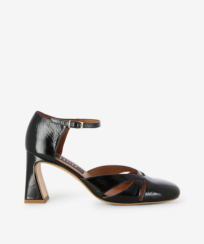 Black crinkle patent leather heels by Neo. It features a tapered block heel, ankle strap with an adjustable pin-buckle closure, and a round toe.