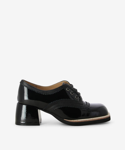 Black patent leather heeled lace-ups by Django &amp; Juliette. It is a lace up style and features a contrasting midsole, pinked-style trim, and a square toe.