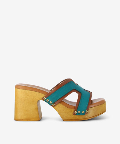 Bold, sculptural, and effortlessly earthy—the Ari Turquoise Combo sandal by Vayah blends retro charm with a handcrafted twist. Leather straps in a striking combo pattern meet a chunky wooden heel feel for a standout style made for those who walk with intention.
• Textured leather straps: Combo-patterned design adds movement and visual interest
• Wooden feel platform &amp; heel: Smooth medium-toned wood for natural lift and vintage structure
• Gold rivet accents: Subtle shine where leather meets wood