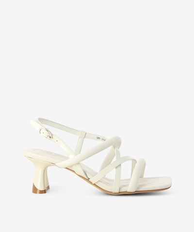 White leather strappy heels by 2 Baia Vista. It features a mixed upper of soft padded straps and patent straps with an adjustable pin-buckle fixture, contoured component block heel, and a square toe.