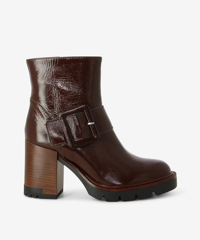 Brown patent leather ankle boots with an upper buckle fastening and features a crinkled patent upper, a block heel and a round toe.