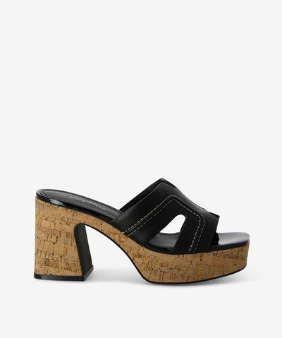 Black leather and cork heels by 2 Baia Vista. It features a cork heel and platform, contrast stitched upper, and a square toe.