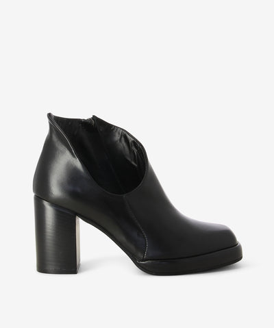 Opened black leather ankle boots with an inner zipper fastening and features an extreme opened ankle with a block heel and a soft square toe.