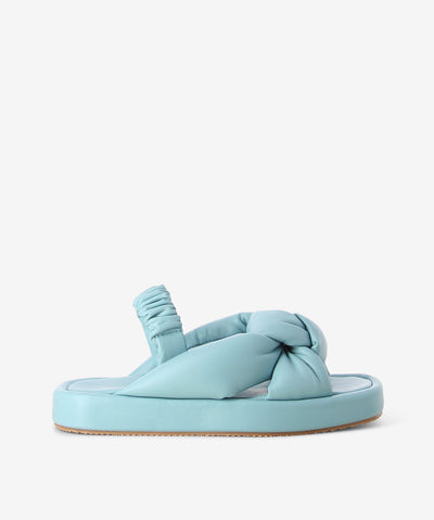 Blue leather sandals by 2 Baia Vista. It is a slip-on style with an elasticated slingback that features knotted cushioned leather straps as its upper, a slight platform sole, and a square toe. 
