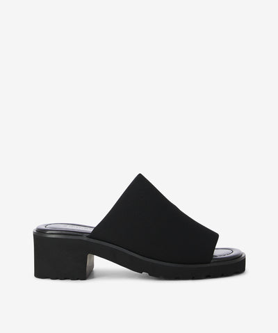 The legend is back! The Daj slides by 2 Baia Vista return in sleek Black textile with a wide vamp, sturdy block heel, and chunky tread sole for a fresh, contemporary edge.
Crafted with breathable mesh stretch fabric, lambskin leather lining, and a feather-light Air EVA outsole, they deliver all-day comfort and effortless style—perfect for both relaxed tailoring and off-duty looks.