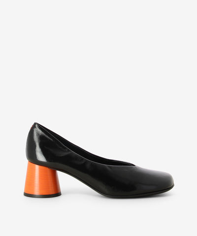 Black patent leather pump from Halmanera. It is a slip-on style and features a contrasting round stacked heel, and a soft square toe.