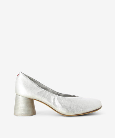 Metallic silver leather pump from Halmanera. It is a slip-on style and features a matching round stacked heel, and a soft square toe.