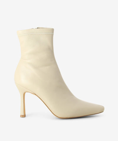 Off-white leather ankle boots by Siren. It features a stiletto heel, inner zip fastening, and a pointed toe.