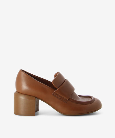 Toffee leather heeled loafer by Officine Creative. It has a soft padded tongue, block heel, and rounded toe.