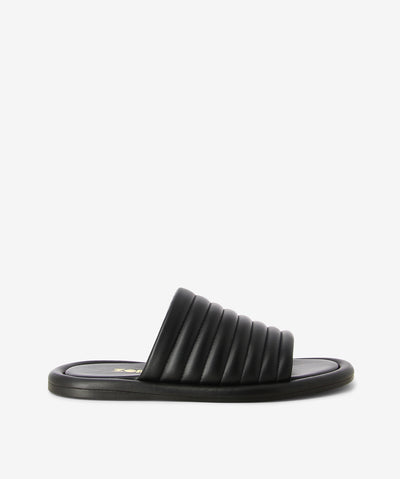 Black leather slides by Zomp. It is a slip-on style and features a quilted-style upper, flat sole and an open round toe.