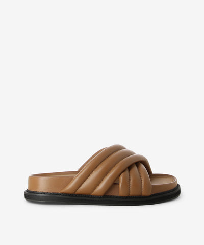 Brown leather cushion slides by AJ Projects. It is a slip-on style and features crossover straps, a moulded footbed and a round toe. 