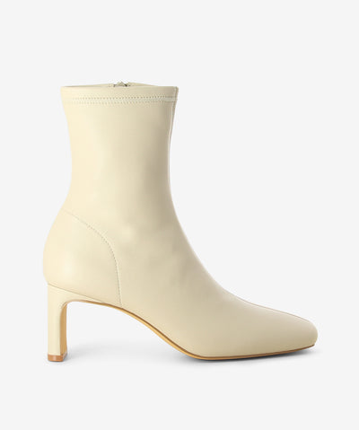Off-white leather ankle boots by Siren. It features a thin rectangular heel, inner zip fastening, and a soft square toe.