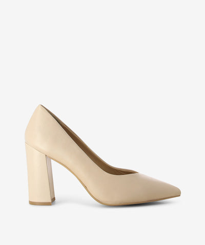 Nude leather pumps by Bruno Premi. It is a slip on style and features a high block heel, and an enclosed pointed toe.