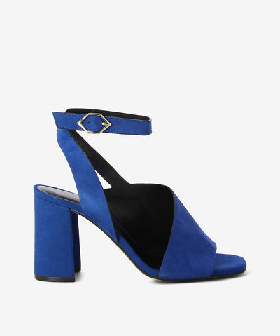 Blue suede leather heels by Bruno Premi. It has an asymmetrical ankle strap and features a block heel and a square toe.