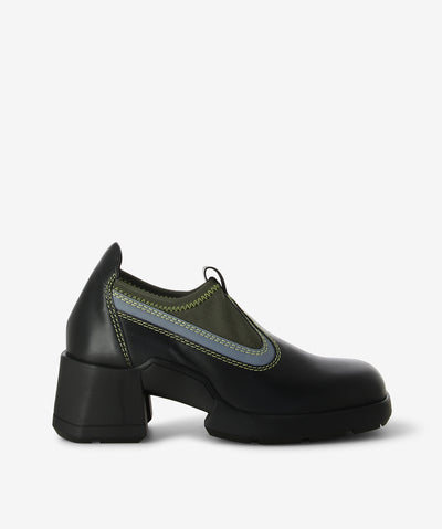 Black leather mule by Miista. A slip-on style and features a stretch reflective lycra sock-effect, a medium block heel and a soft square toe.