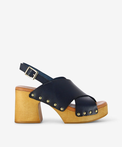 Vintage soul, modern stride—meet the Phoebe Navy sandal. A rounded toe, supple navy leather, and a sculpted wooden block heel bring earthy elegance to every step, effortlessly balancing timeless craftsmanship with contemporary style.
• Premium leather upper: Rich navy tone with wide strap and gold buckle for a secure fit
• Wooden block like heel: Smooth medium-toned finish for natural texture and confident lift
• Gold rivet detailing: Subtle hardware accents where leather meets wood