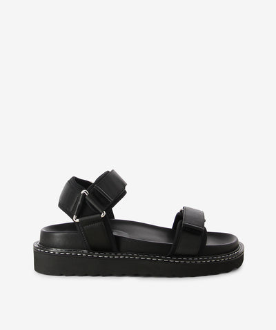 Black sandals by Caverley. It has velcro strap fastening and features a satin-finished strap, moulded footbed and a round toe. 