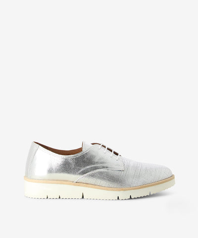 Metallic silver leather sneakers by Nu by Neo. It is a lace-up style featuring a textured metallic finish, a flex sole and a pointed toe.