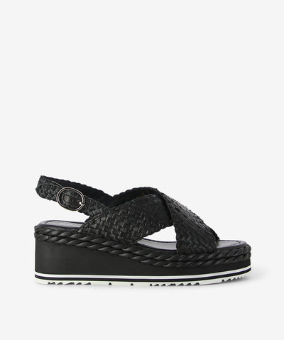 Step into easy sophistication with Scope by Bresley. Crafted in a deep Black woven leather, this sandal blends texture and comfort seamlessly. The cross-over front straps create a flattering silhouette with rounded toe, while the adjustable slingback ensures a secure fit for all-day wear. Set on a chunky wedge sole with subtle braided detailing, Scope delivers height without sacrificing comfort — perfect for laid-back weekends or casual summer days. Finished with a contrasting tread sole for a modern touch.