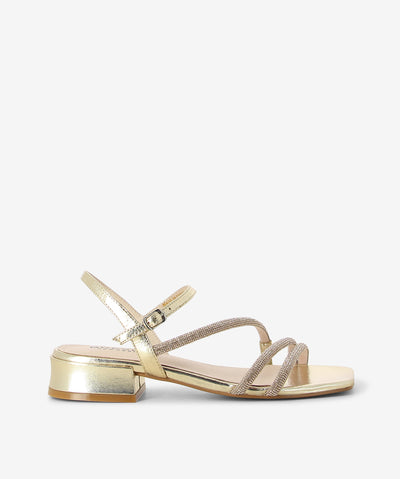 The Gold Sippa sandal by Bresley offers radiant minimalism with a touch of sparkle. Crafted in metallic gold leather, it features two rhinestone-adorned straps, a sleek ankle buckle, a low block heel for all-day comfort and a square toe. Perfect for festive nights or chic daytime looks.