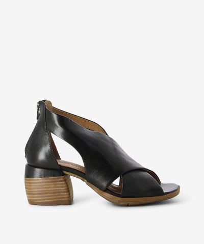 Black leather mules by Martini Marco. It has a large cross strap upper, back zipper, and a square toe.