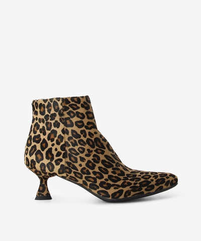 Leopard print pony hair ankle boots by Martini Marco. It features a tapered triangular heel, side zip closure, and a pointed toe.