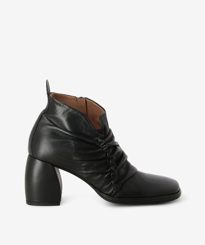 Black leather ankle boots with an inner zip fastening and features ruched leather detailing, a block heel and an anatomic square toe.