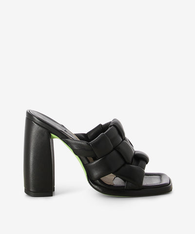 Black leather mule by Ixos. It features a thick woven upper, high block heel, and a square toe.
