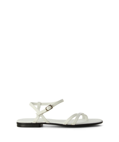 White leather flat sandals featuring an ankle strap with a buckle fastening, a criss-cross strappy upper and a soft round toe.