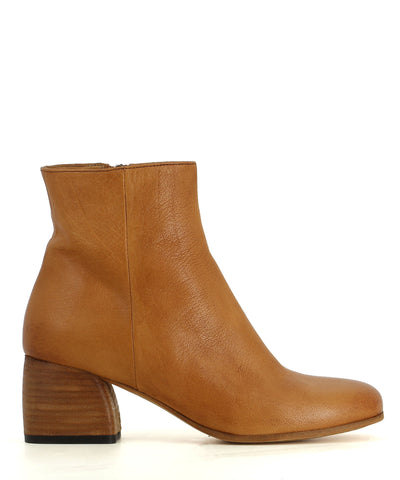 An tan leather ankle boot featuring a zipper fastening, soft round toe, and a block heel. 