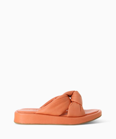 Orange leather platform slides with a knotted strap, cushioned insole and a soft square toe.
