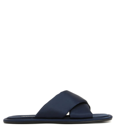 A midnight blue satin flat slide featuring a square toe and crossover strap