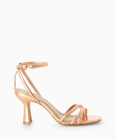 Rose gold metallic leather heels with an ankle strap fastening and featuring a strappy upper, an hourglass heel and a round toe.