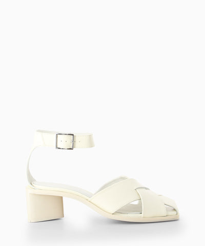 White leather heeled sandals with enclosed crossover straps, a triangular heel and a soft square toe.