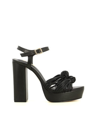 A black leather platform sandal featuring knotted toe straps, a buckle fastening and an almond toe. Made by ZOMP - this style runs true size. 