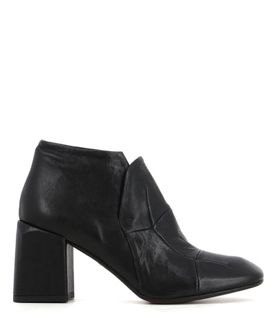 A black leather ankle boot featuring a soft square toe, block heel, and paneled leather detailing. 